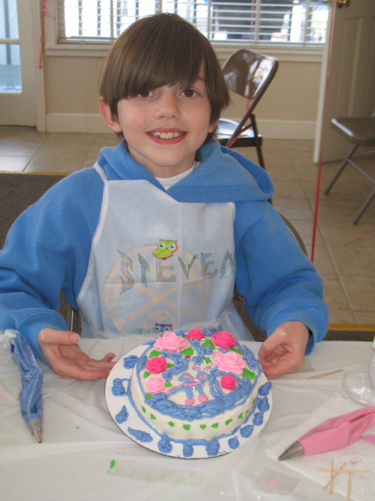 Young Boy showing the cake he decorated himself